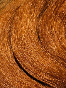 Curled t33/amber hair extensions on a white surface