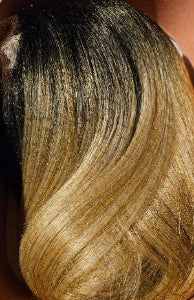 Close-up of a hair extension with black to blonde gradient