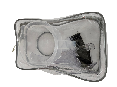 Clear plastic bag with cosmetic items including a brush and container on a white background