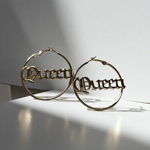 Gold hoop earrings with 'Queen' engraving on a white background