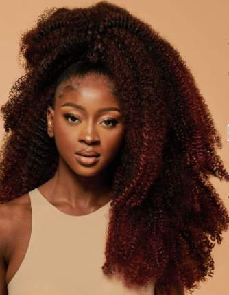 Woman with voluminous curly hair against a beige background